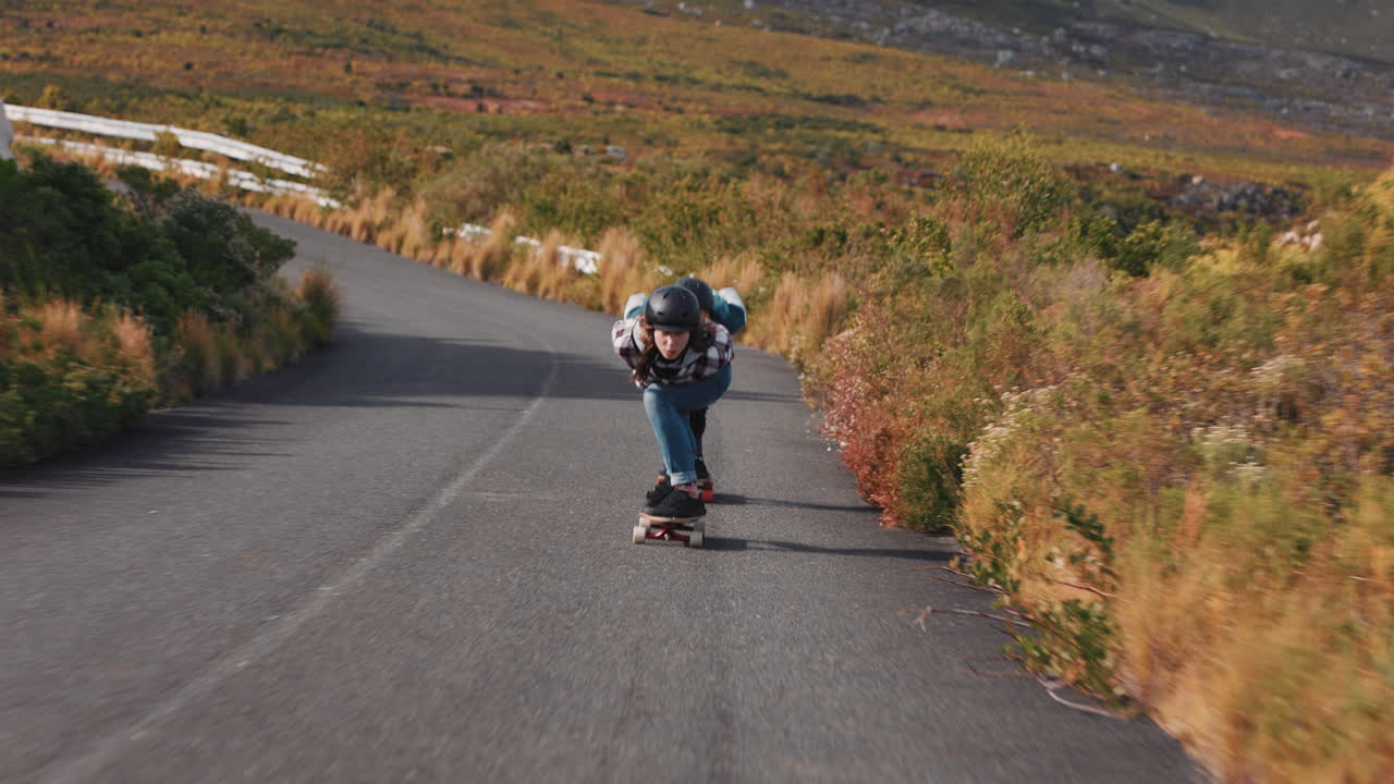 amigos jóvenes longboarding juntos crucero en la carretera del campo divirtiéndose montando en patineta con casco protector adolescentes felices carreras