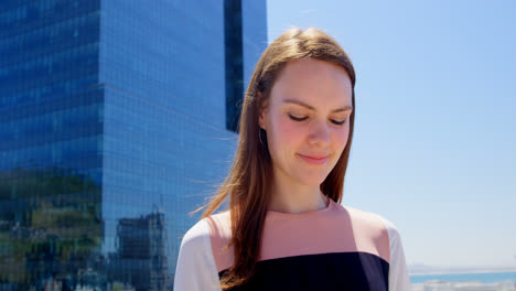 front view of young caucasian businesswoman looking down and standing in office balcony 4k