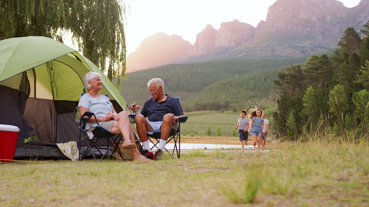Family returning to grandparents&rsquo; tent on camping holiday