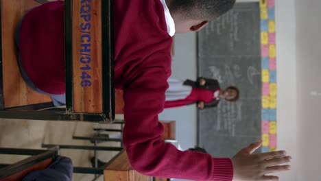 Vertical---Male-Student-Raising-Hand-During-Discussion-In-African-Classroom-In-Uganda