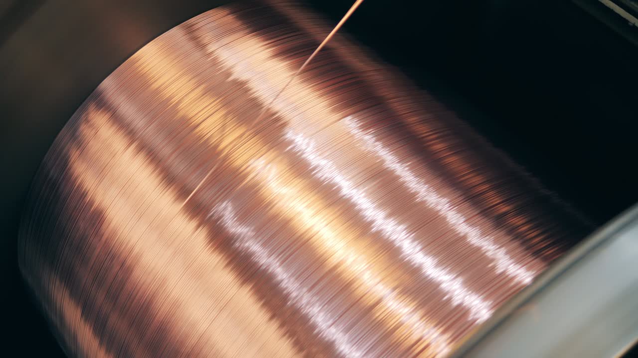 Rotating spool with copper wire getting unwound