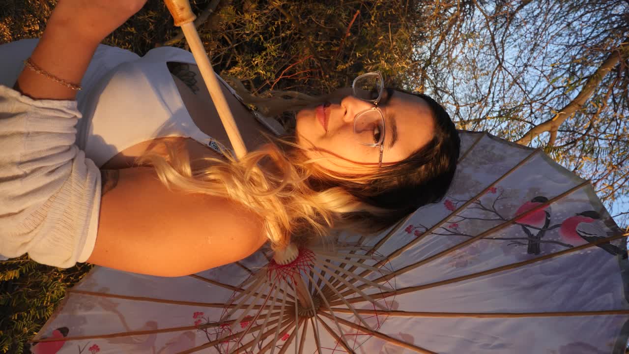 Beautiful girl with an umbrella at sunset