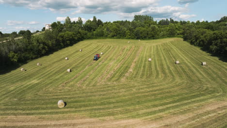 Vista-Aérea-Del-Tractor-Haciendo-Fardos-De-Heno-Redondos-En-Los-Campos-Rurales.