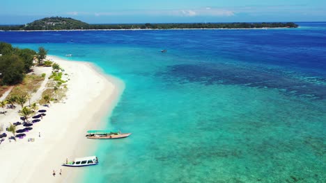 Large-coral-reefs-seen-through-clear-water-of-turquoise-lagoon-surrounding-white-sandy-beaches-of-tropical-island,-well-known-destination-for-holidays-in-Bali