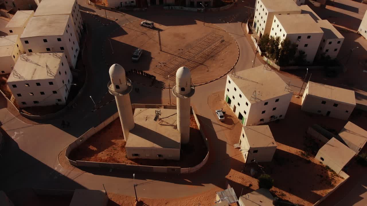 aerial shot of two mosques at palestine near gaza in the desert revealing empty city.