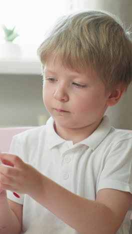 adorable little boy learns cards with digits and fans in preschool classroom on hot day. curious toddler child rests in kindergarten at mathematics lesson