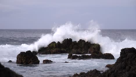 scenic landscape of ocean waves crashing on rocks, slowmotion