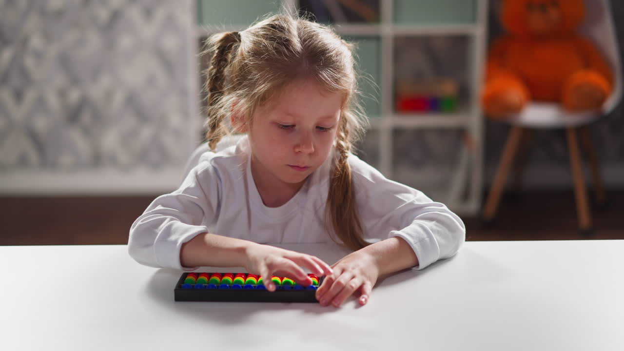 Una bambina impara il calcolo mentale con un abaco giocattolo.