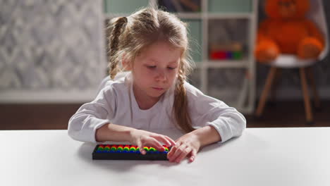 little girl learns mental mathematics with toy abacus