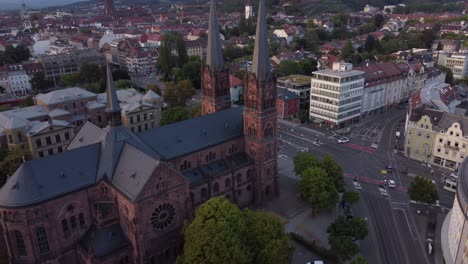 aerial view revealing catholic church building in the center of gothic old town of freiburg im breisgau during sunset, germany