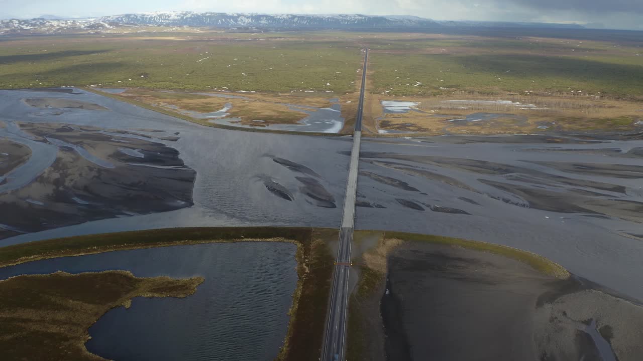 vista aérea descendente de la conducción de automóviles en el puente sobre el río eldvatn en islandia - toma panorámica cinematográfica del paisaje escénico en islandia