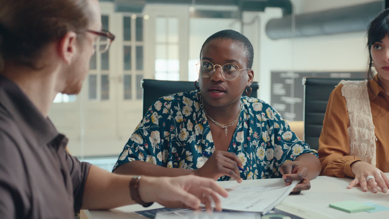 Manager Checking Papers and Speaking with Female Employees on Office Meeting