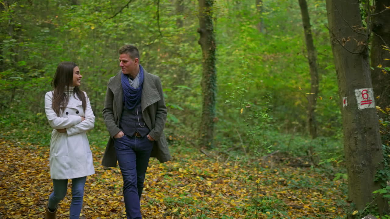 가을의 숲에서 산책하는 부부