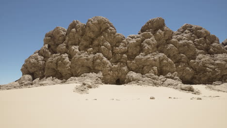 un grupo de rocas sentadas en la parte superior de una playa de arena