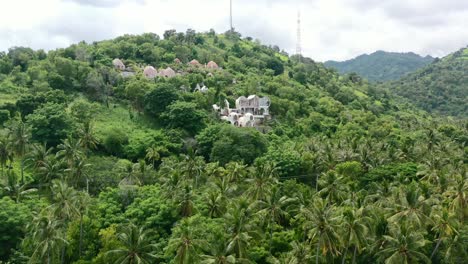 Tropical-island-getaway-with-white-sand-beach-and-beautiful-mountain-dome-villa,-aerial