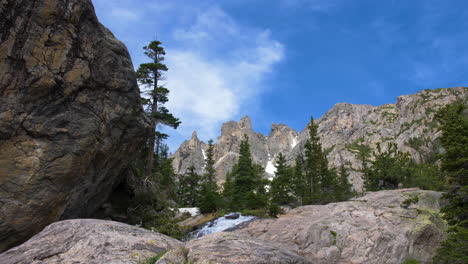 Fluss-Fließt-Durch-Granitfelsen-In-Den-Felsigen-Bergen-Mit-Blauem-Himmel-Und-Wolken-Hinter-Kiefern