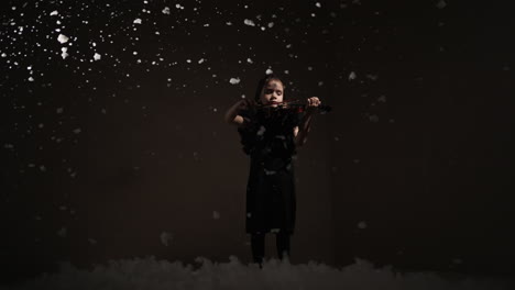 young girl playing violin in a winter scene