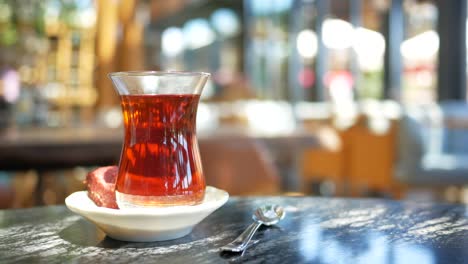 a glass of turkish tea with a turkish delight