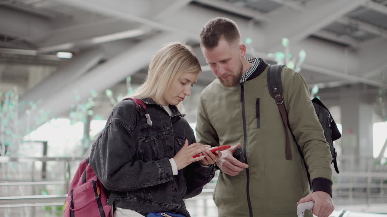 pareja usando un teléfono inteligente en el aeropuerto