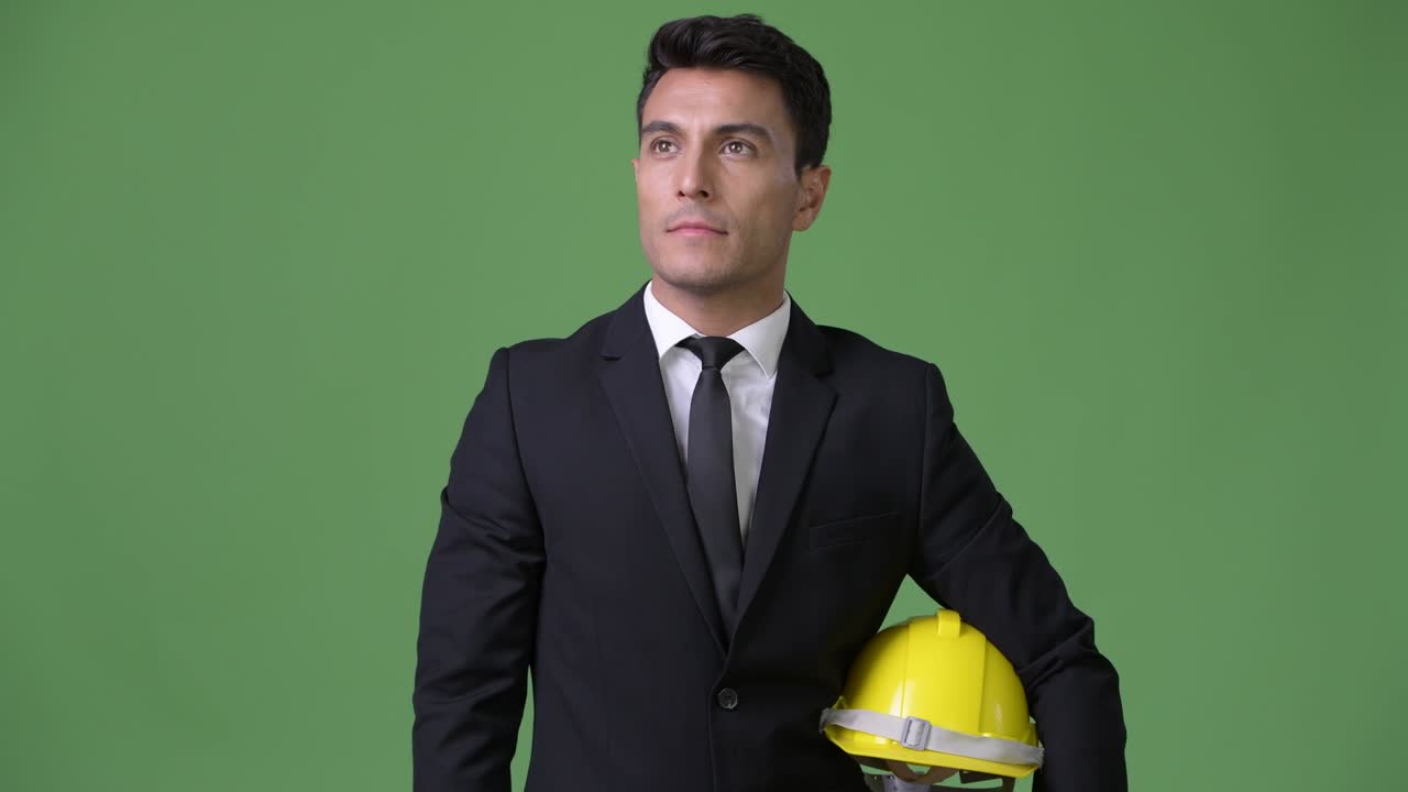 초록색 배경에 젊은 잘생긴 히스패닉 사업가