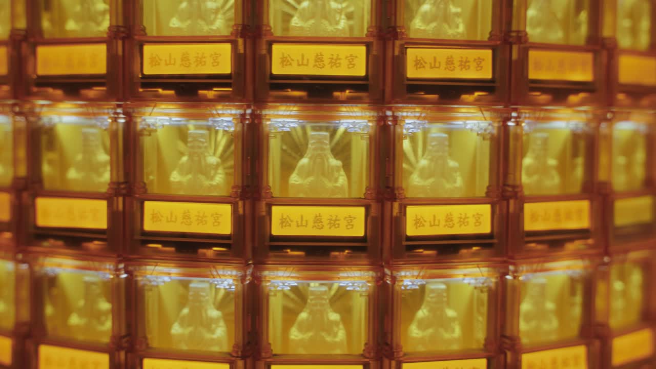 Symmetrical close-up of many golden Buddha statues glowing in illuminated niches at Ciyou Temple in Taiwan, symbolizing devotion, peace, and spiritual reverence in a sacred Buddhist space