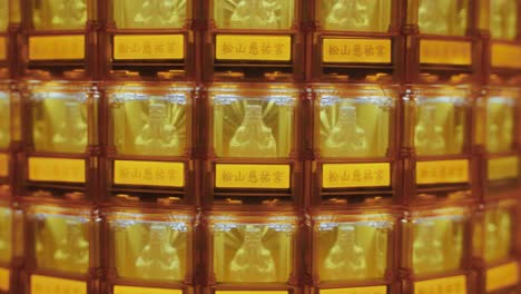 symmetrical close-up of many golden buddha statues glowing in illuminated niches at ciyou temple in taiwan, symbolizing devotion, peace, and spiritual reverence in a sacred buddhist space