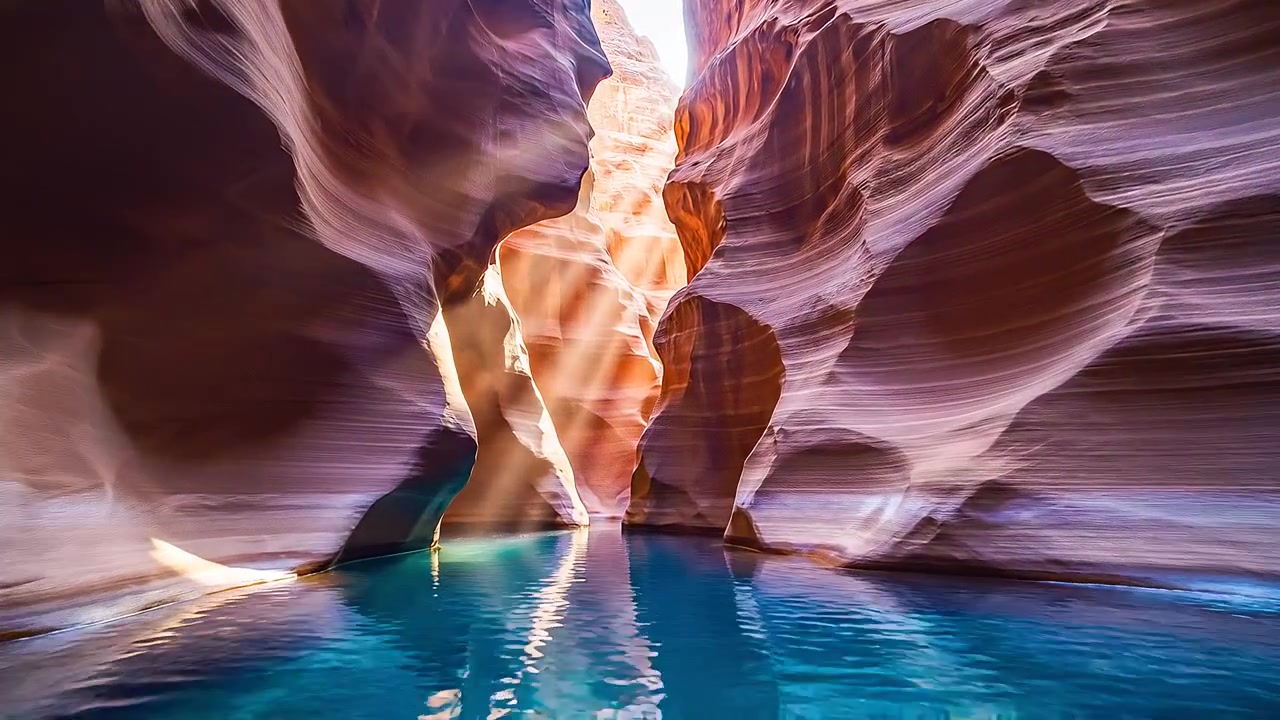 Raggi di sole che illuminano un canyon a fessura su acqua turchese