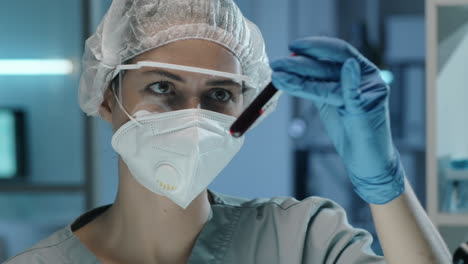 Female-Lab-Scientist-Examining-Blood-in-Test-Tubes