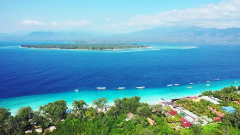 vivid colors of blue azure sea stream between two tropical islands with lush vegetation and white sandy beaches in gili, indonesia