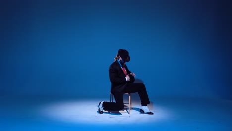 man in suit and fedora performing on blue stage