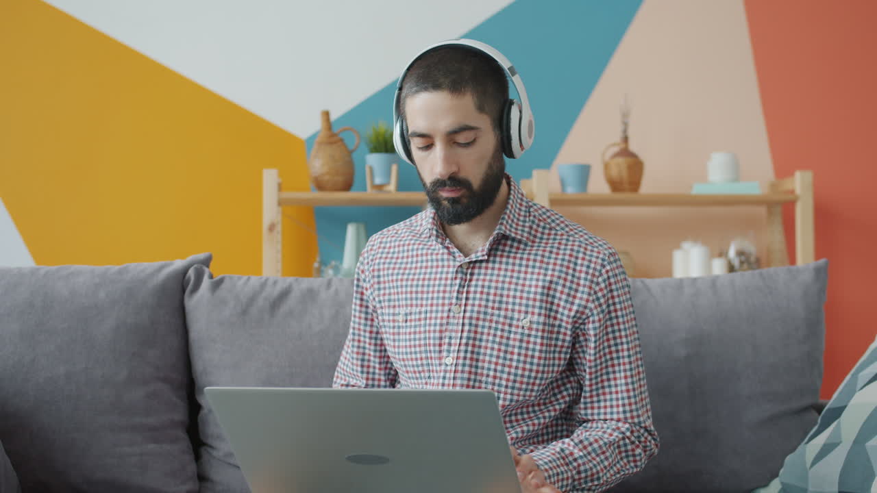 Man working from home on laptop with headphones