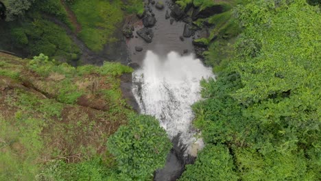 aerial birds eye view shot tracking sipi river as it falls over the edge of a large cliff into a green valley