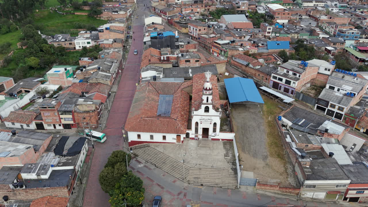 Aerial footage of Parroquia Nuestra Señora De Los Dolores surrounded by a bustling townscape. The vibrant urban scenery and historic architecture are captured under natural lighting