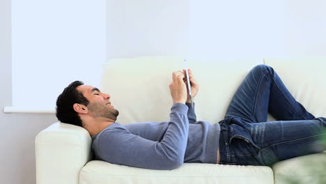 man using a tablet on the couch