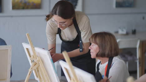 Vista-Lateral-De-Una-Gente-Mayor-Feliz-Sonriendo-Mientras-Dibuja-Como-Actividad-Recreativa-O-Terapia-En-Clase-De-Pintura-Junto-Con-El-Grupo-De-Mujeres-Y-Hombres-Jubilados