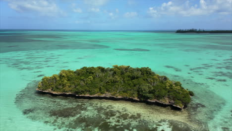 Fast-reverse-aerial-flying-low-over-tiny-island-off-Isle-of-Pines-coast