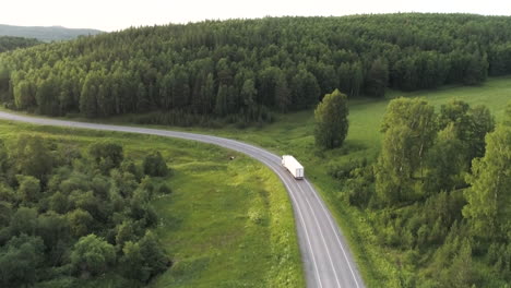 truck on a winding country road through forest