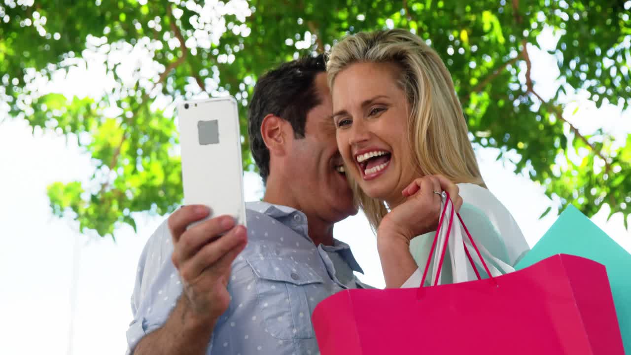 pareja feliz tomando un selfie desde un teléfono móvil en un día soleado