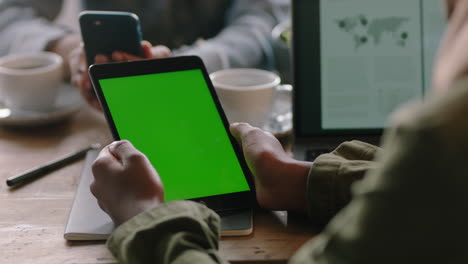 mujer de negocios que usa una tableta viendo la pantalla verde en un dispositivo móvil clave de croma disfrutando del entretenimiento en línea leyendo publicidad en redes sociales en un café de cerca
