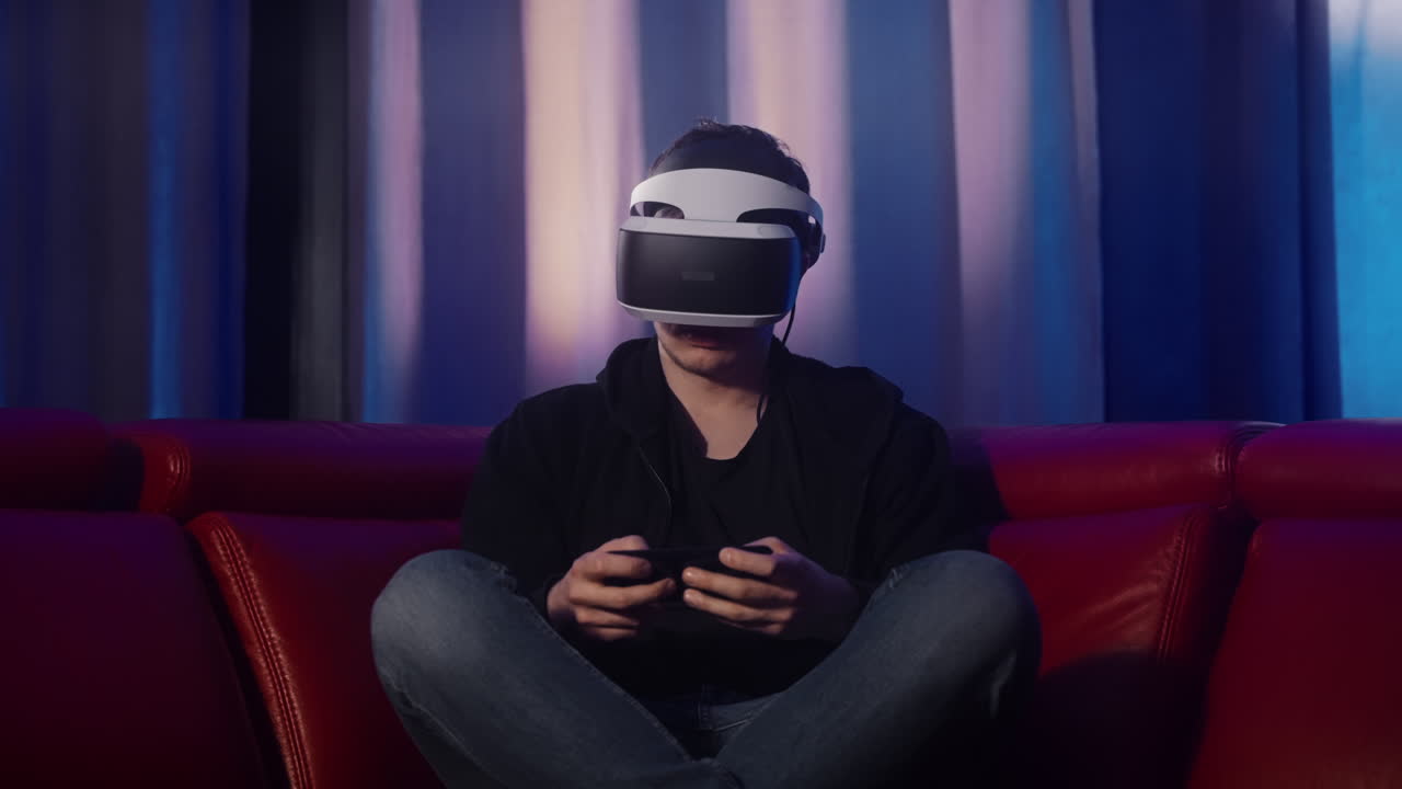 Uomo che gioca a un gioco VR su un divano