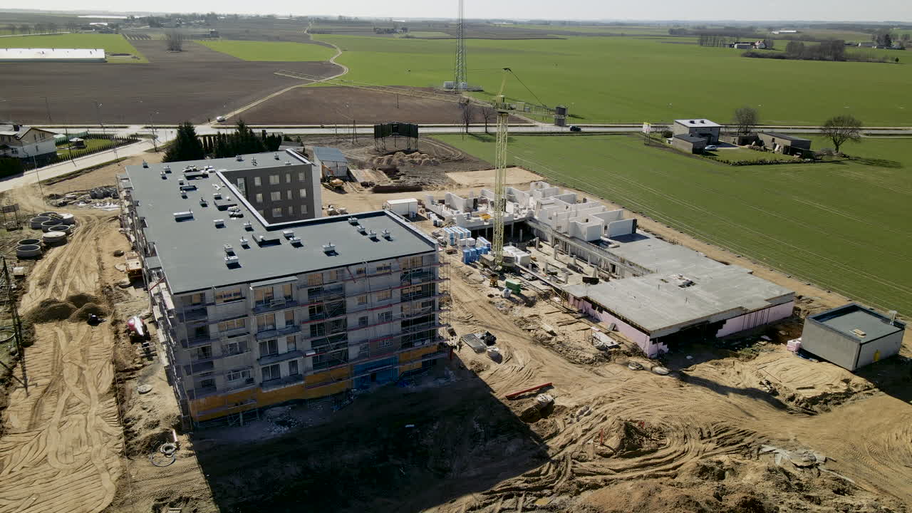proceso de construcción de un edificio de varias plantas con prados verdes de fondo en lubawa, polonia