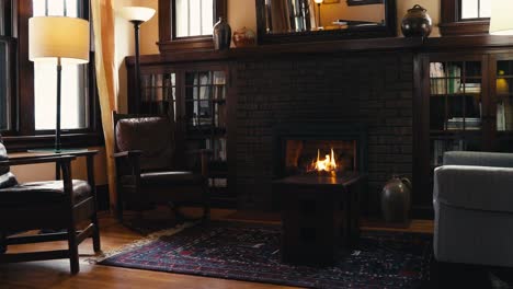 medium tight shot of a gas fireplace lit in the living room of a home in front of a coffee table with 2 leather chairs and a couch