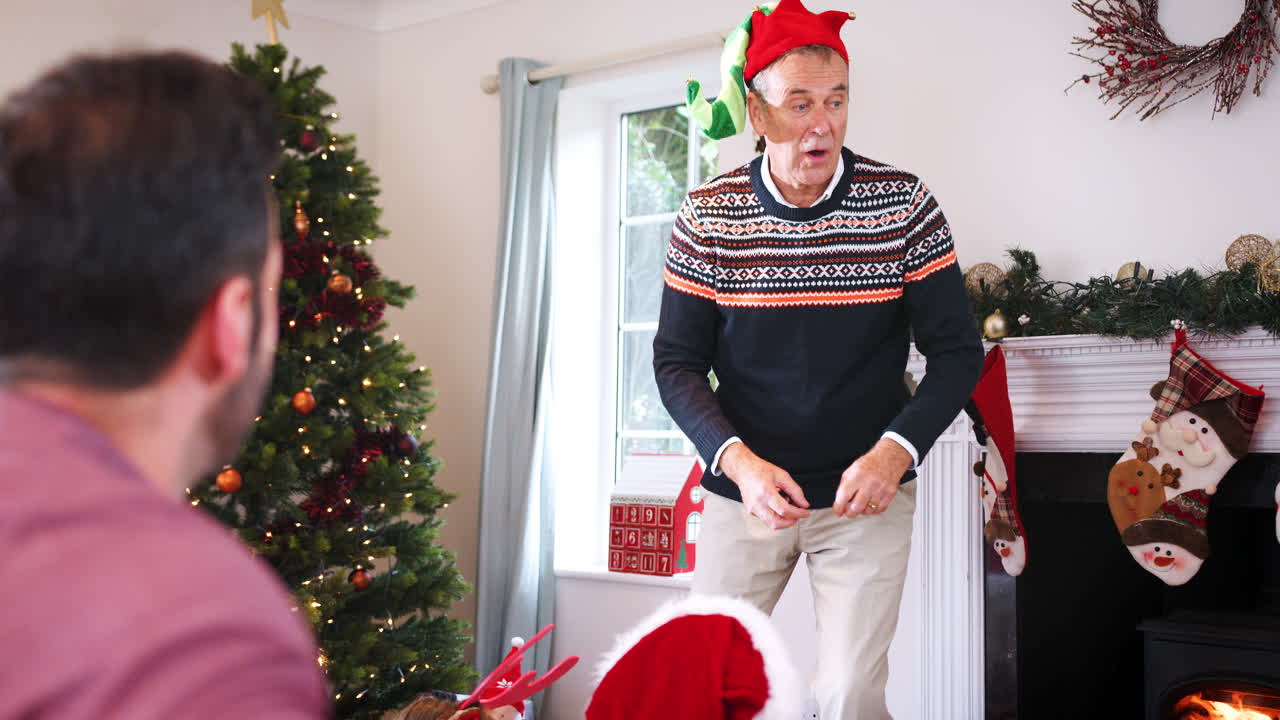 abuelo actuando como mimo como familia de varias generaciones jugando juegos de charadas navideñas en casa juntos