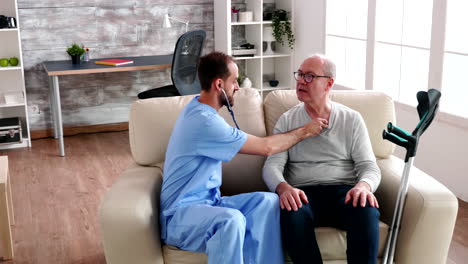 nursing male using stethoscope to check old man heart beat