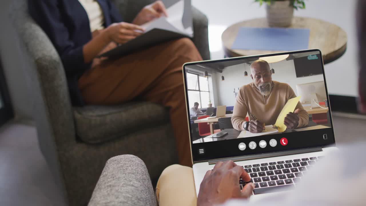 African american man using laptop for video call, with business colleague on screen