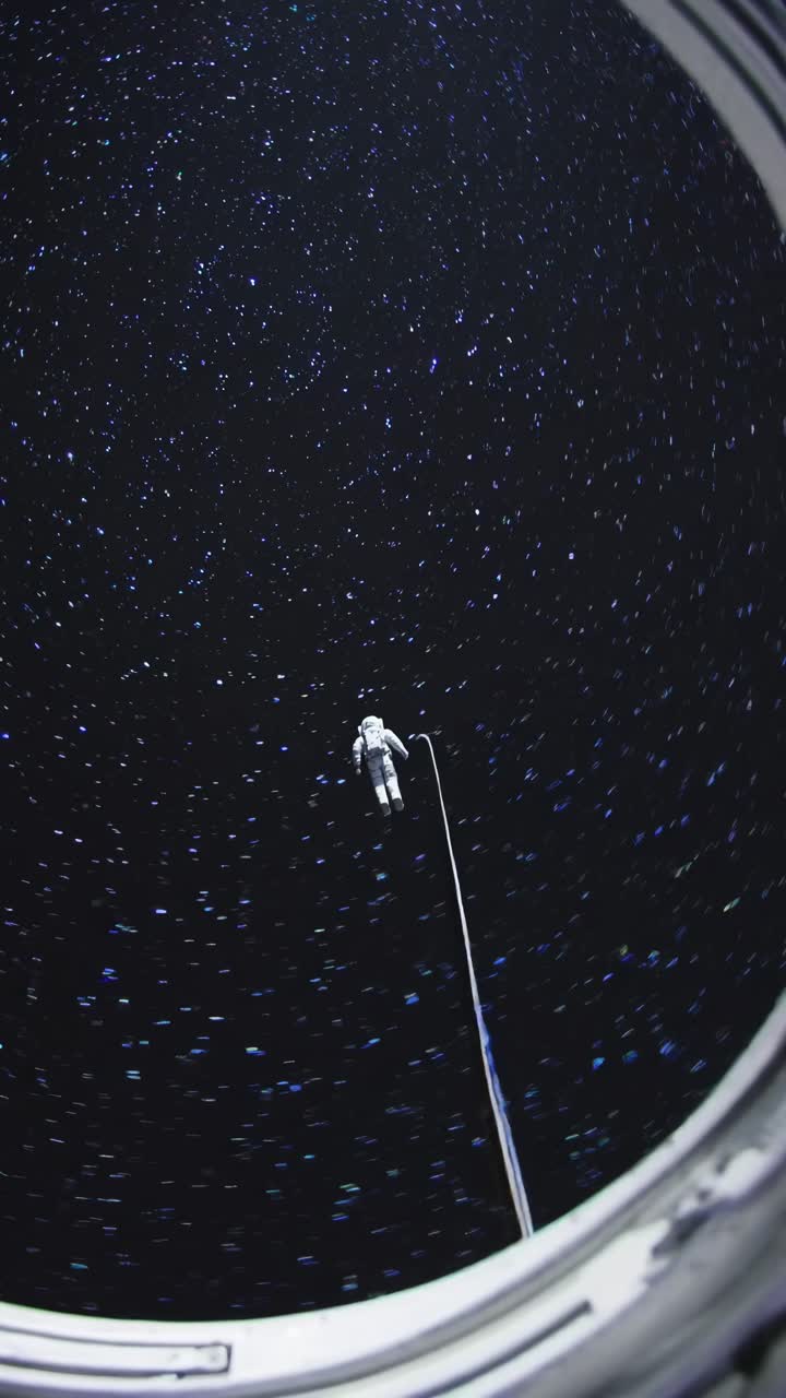 A video still shows an astronaut tethered in space, captured from a low-angle view