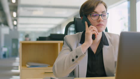 businesswoman using laptop and talking on phone