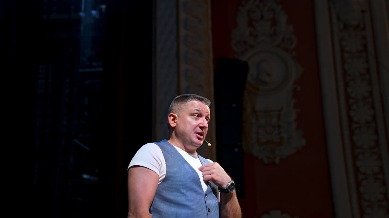 Speaker perform a monologue on stage. Professional actor on stage speaking and gesticulating in theater.