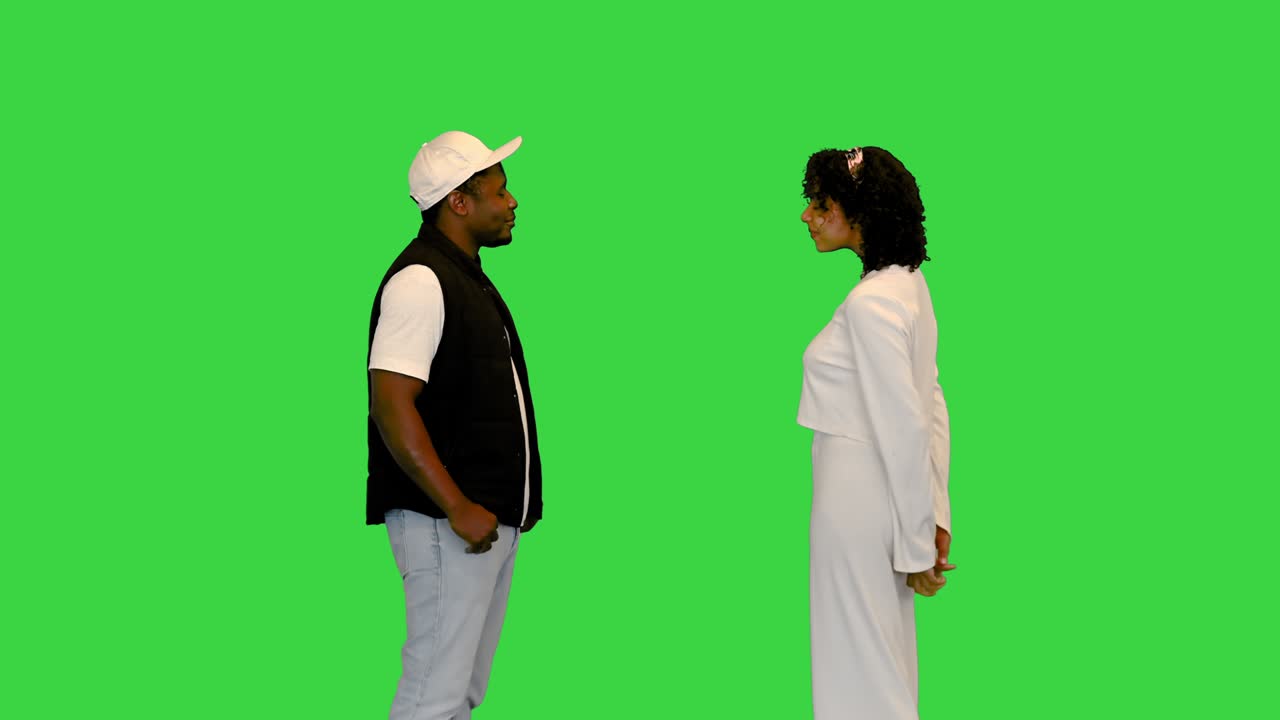 un hombre y una mujer afroamericanos se saludan en una pantalla verde, clave de croma