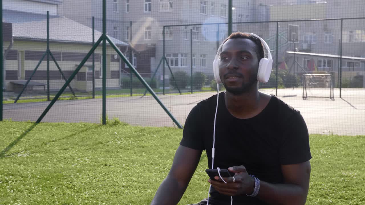 Mann lytter til musikk i en park